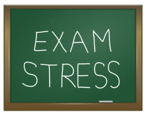 Illustration depicting a green chalk board with the words 'exam stress' written on it in white chalk.